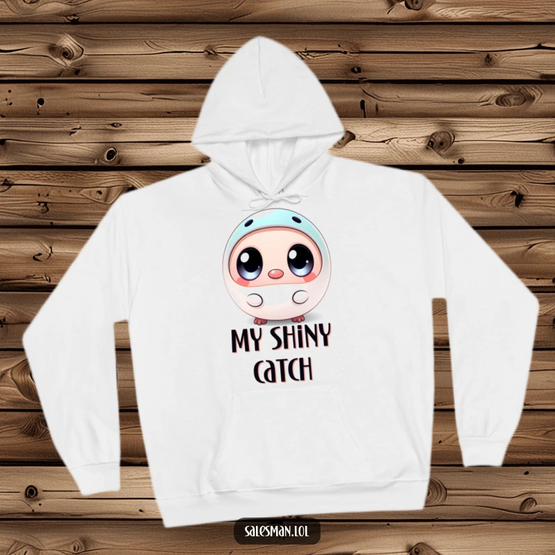 Funny hoodie print of a round creature with big eyes, holding a small, shiny sample, radiating an adorable and humorous vibe.